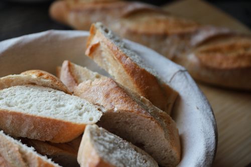 Free Delicious slices of fresh baguette in a basket, perfect for bakery presentations. Stock Photo