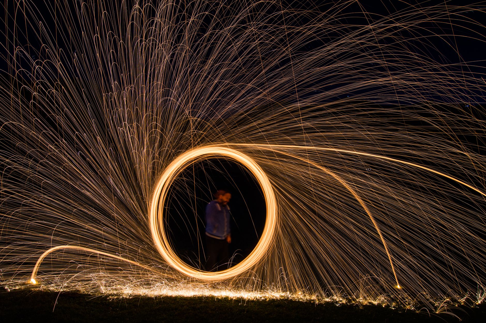 Vibrant steel wool light painting creating circular spark trails at night in Giresun, Türkiye.