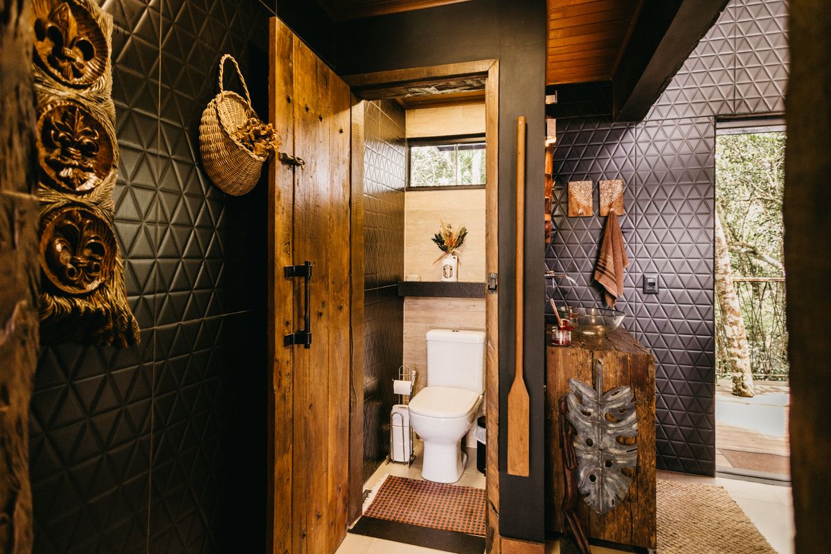 Cozy rustic bathroom with wooden design elements and textured walls in Espírito Santo, Brazil. Stock Photo.