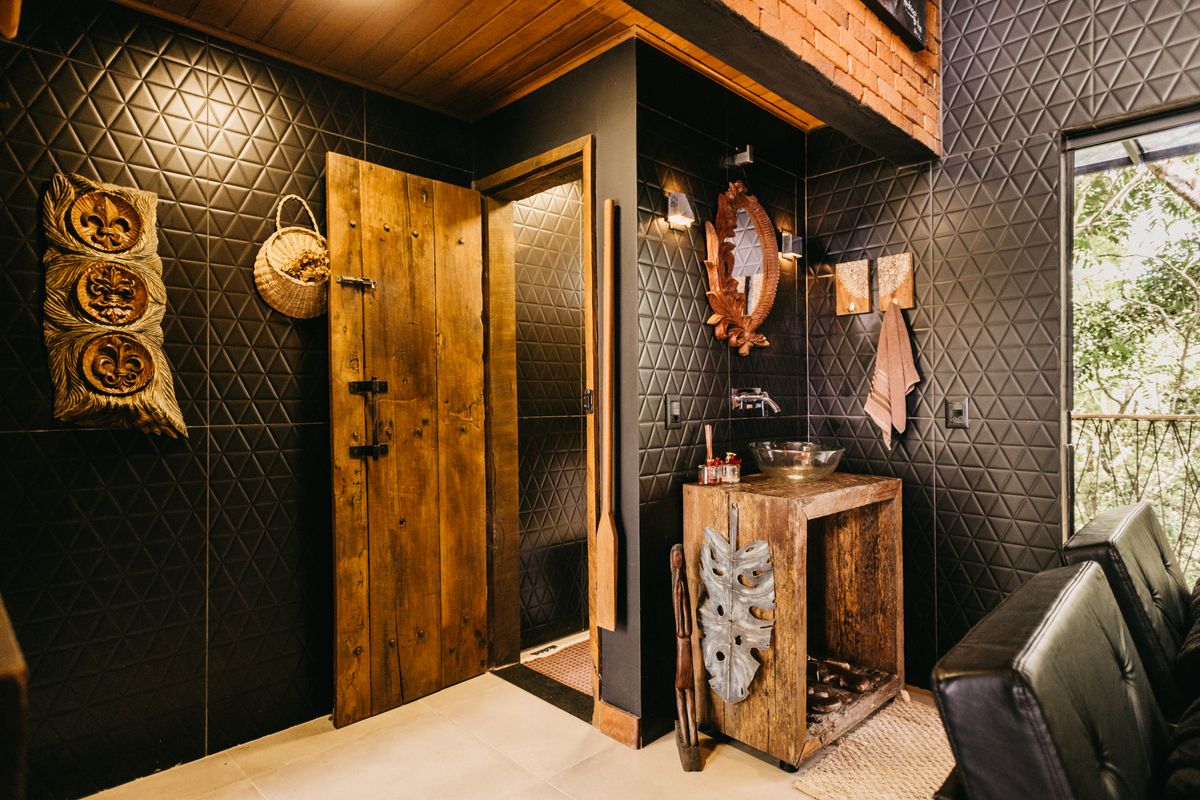 Cozy rustic bathroom interior with wooden elements and tribal art in Espírito Santo. Stock Photo.