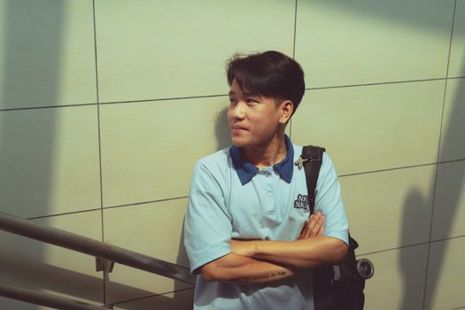 A man standing casually against a tiled wall in Ho Chi Minh City, Vietnam.