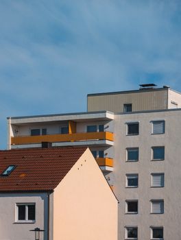 A modern residential building complex with contrasting architecture against a clear blue sky.