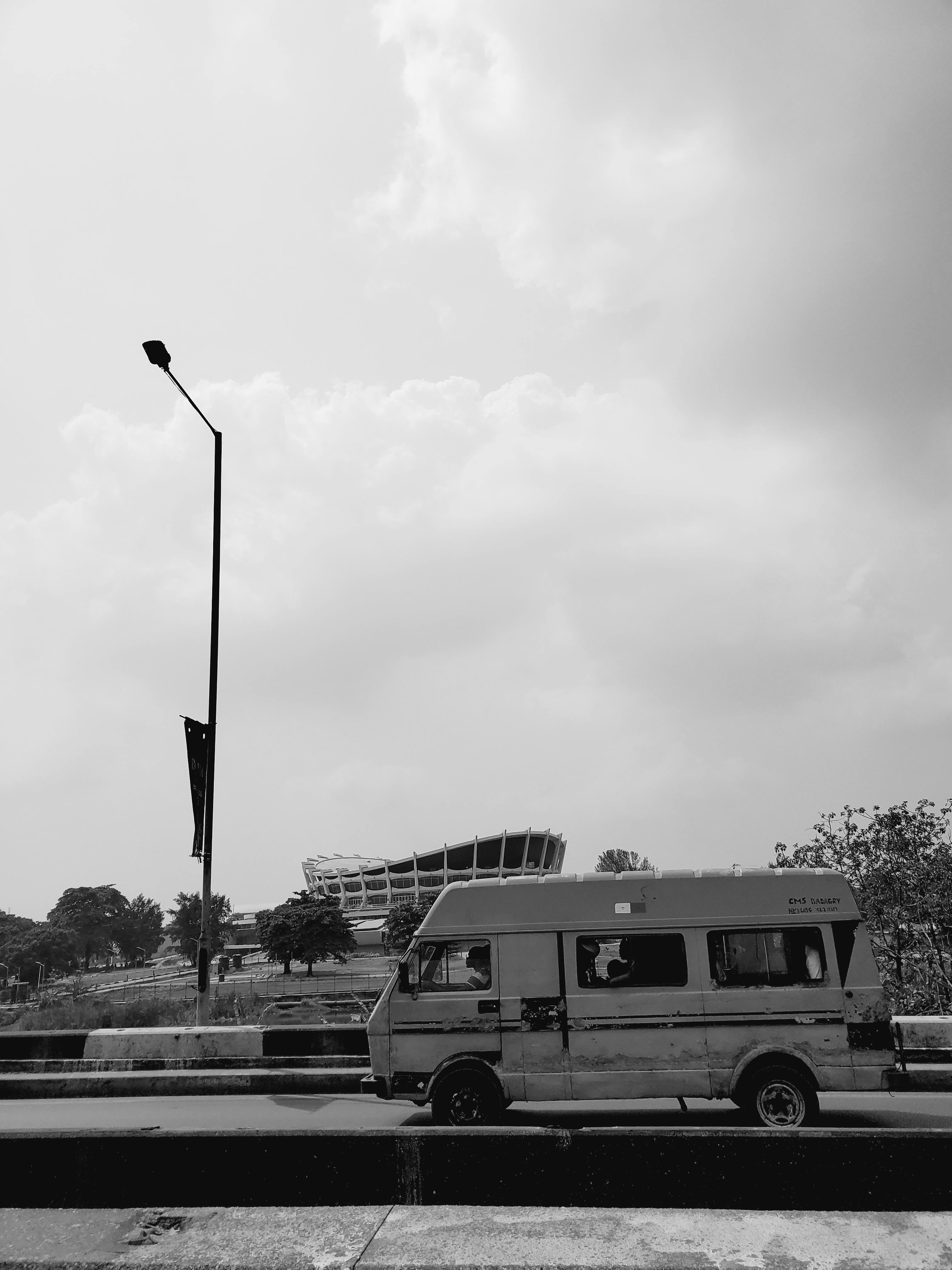 Free Black and white image of a van near a landmark in Lagos, Nigeria. Stock Photo