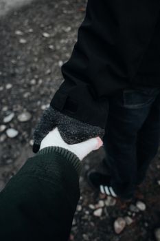 Two people holding hands on a wintry walk, symbolizing connection and togetherness.