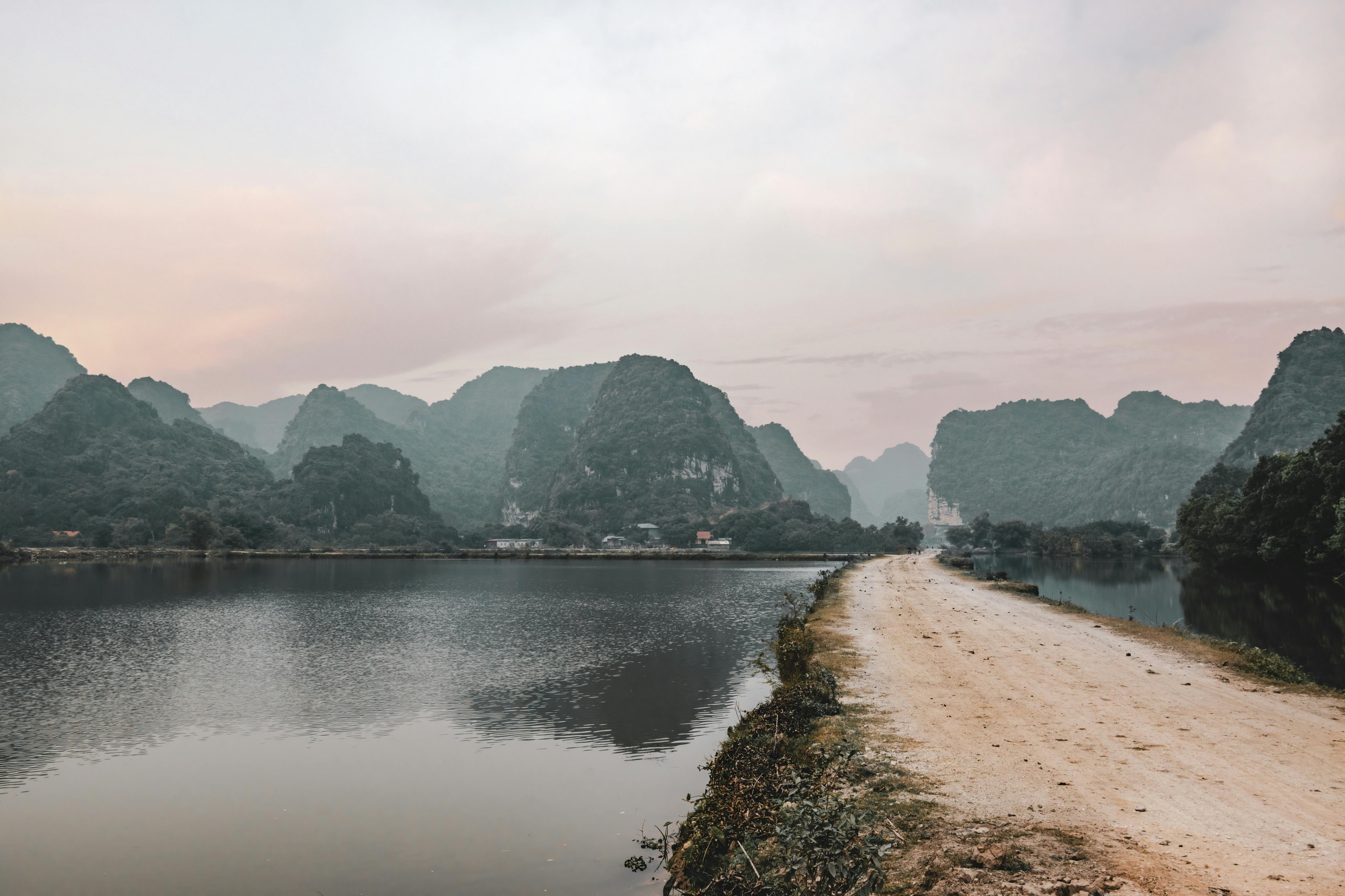Peaceful landscape of limestone mountains reflected in water at Hoa Lư, Vietnam.