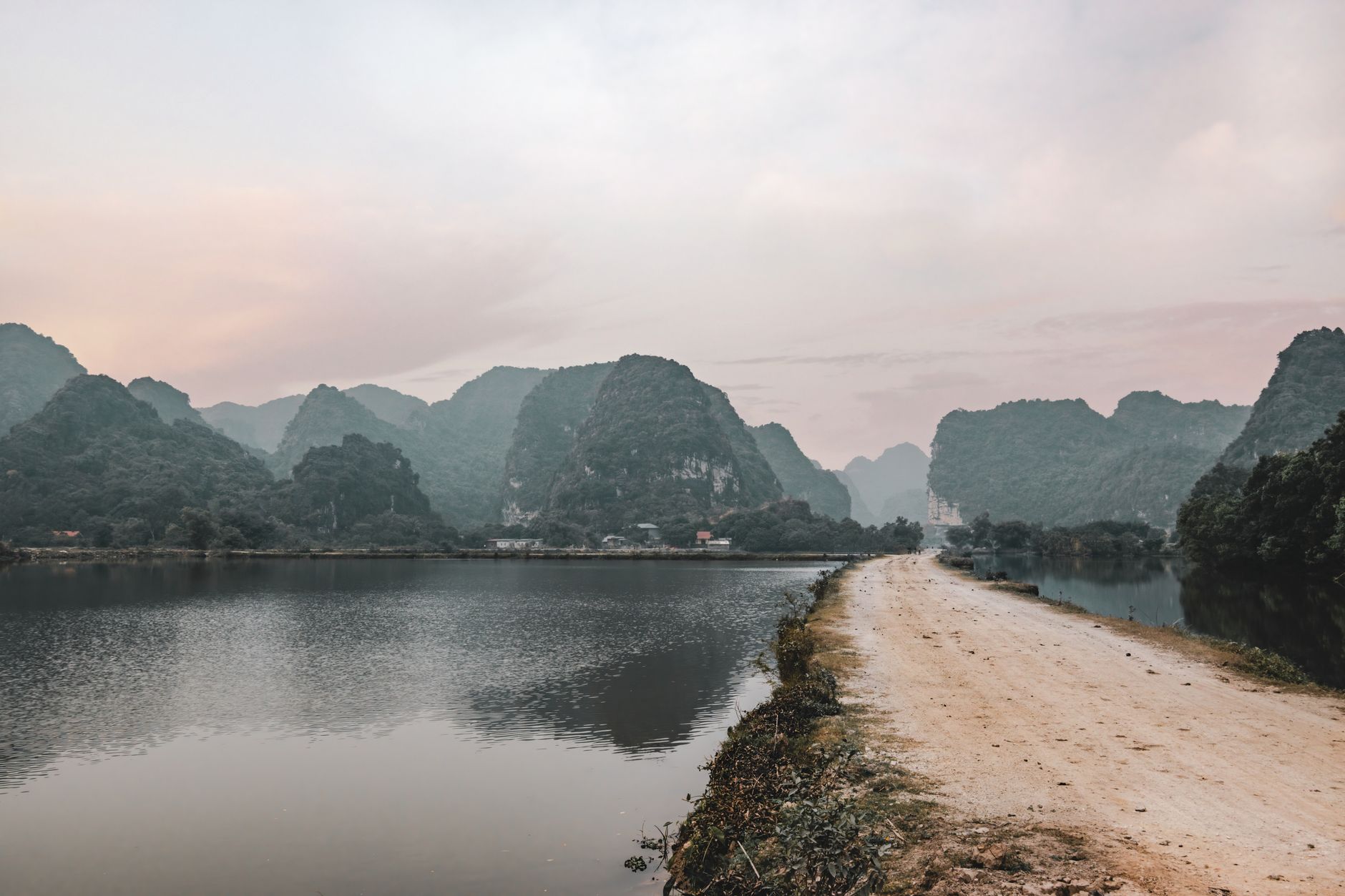 Peaceful landscape of limestone mountains reflected in water at Hoa Lư, Vietnam.