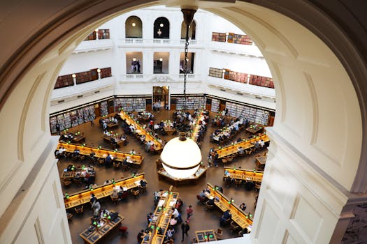High-angle shot of a crowded dome library room with study tables and shelves.
