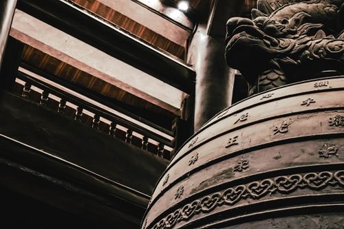 Free Detail of an ancient bronze bell featuring a dragon design and intricate patterns, indoors. Stock Photo