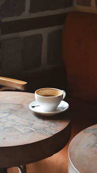 Warm cup of coffee on a rustic table in a cozy cafe setting.