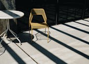 时尚的户外露台沐浴在明亮的阳光下，配有现代化的桌椅