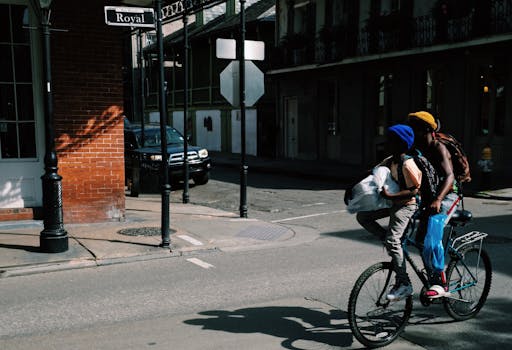 Two people biking on Royal Street in New Orleans, capturing urban transport and street life.