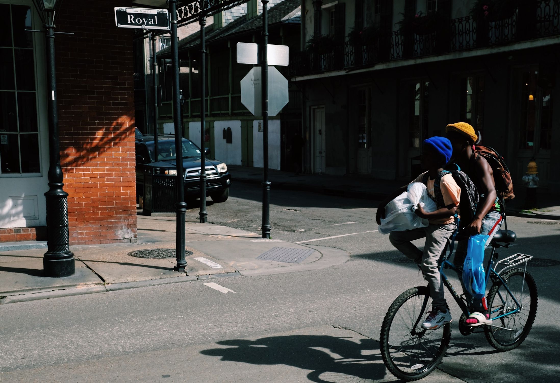 Two people biking on Royal Street in New Orleans, capturing urban transport and street life.