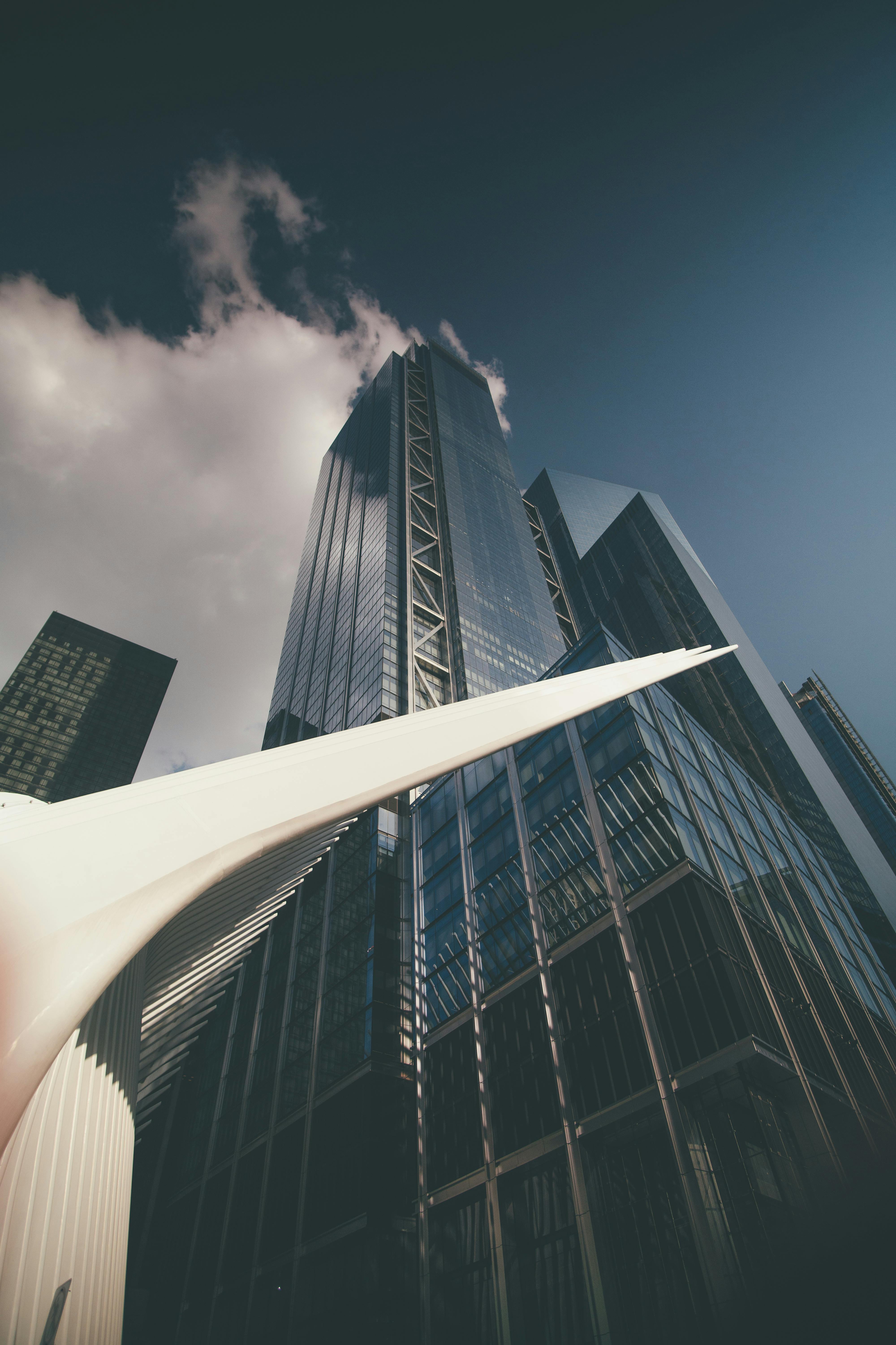 纽约市一座现代摩天大楼的低角度视图，天空云层引人注目