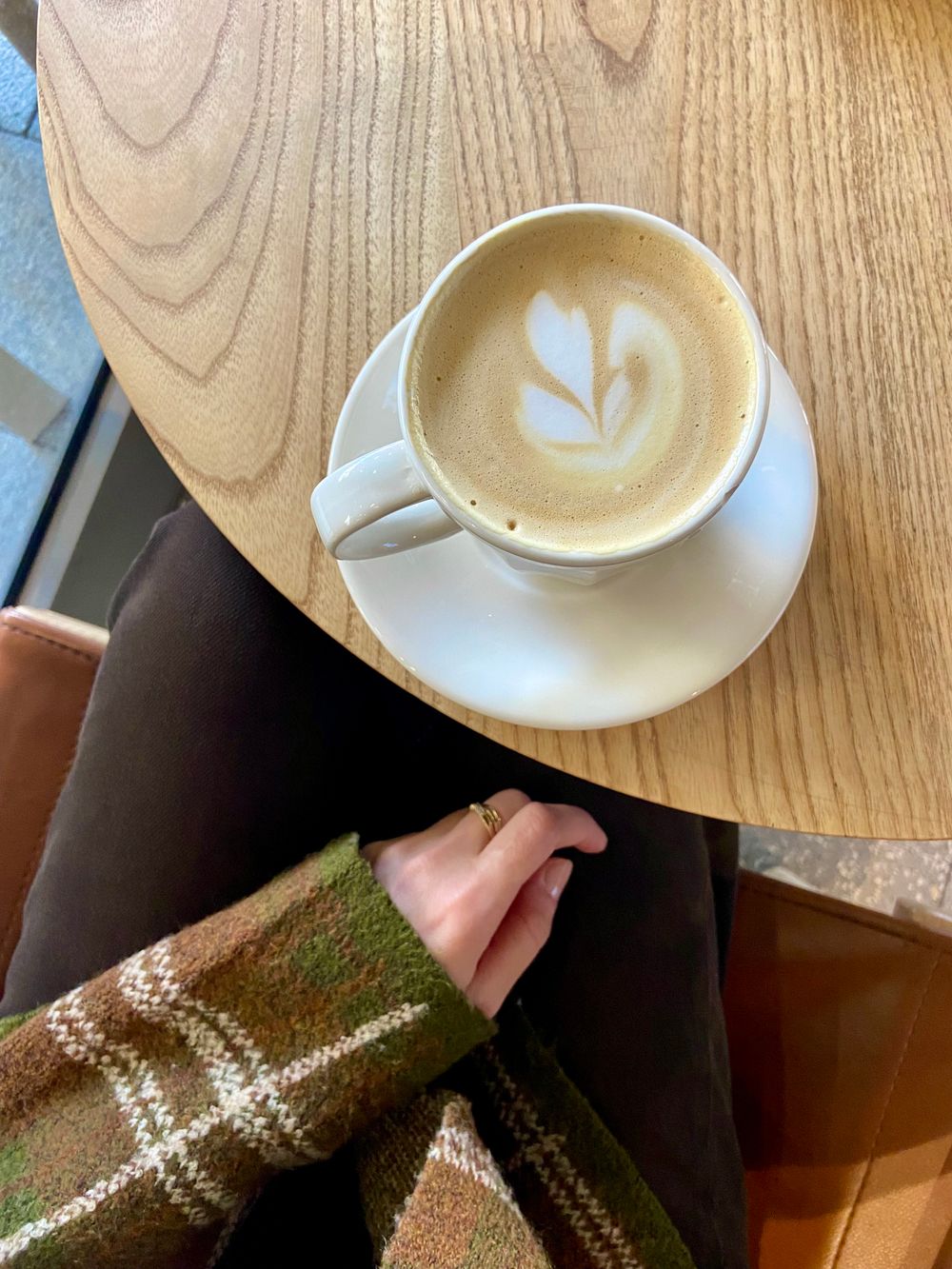 A cup of latte on a wooden table (placeholder photo)