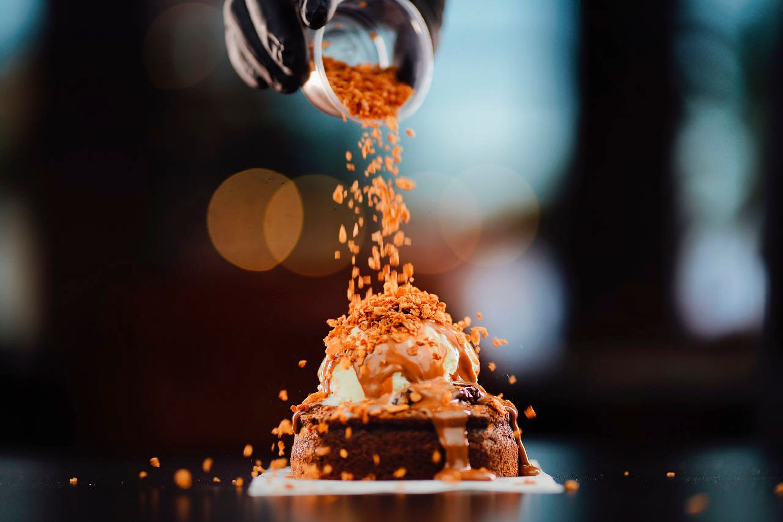 close-up of miso caramel drizzling over a brownie with sea salt flakes