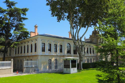 Free Bright view of the historic Dolmabahçe Palace in Istanbul, Türkiye, surrounded by lush greenery. Stock Photo