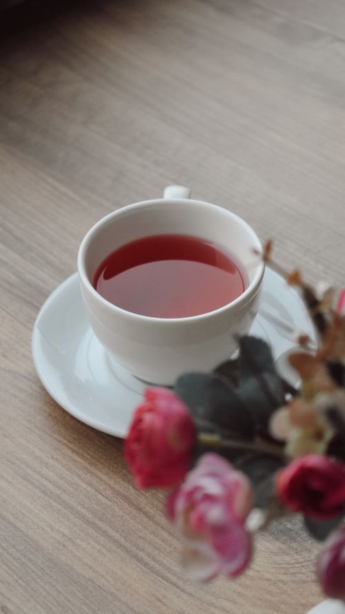 Free A calming cup of tea by a window with pink flowers in view, perfect for relaxation. Stock Photo