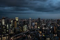 黄昏时分，喜怒无常的云层映衬下，大阪戏剧性的天际线展现出明亮的摩天大楼