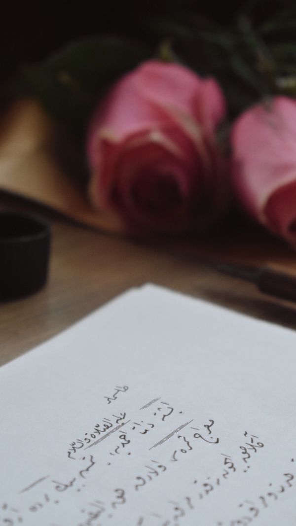 Red Roses Calligraphy Elegant Calligraphy with Roses and Ink on Wooden Desk · Free Stock Photo