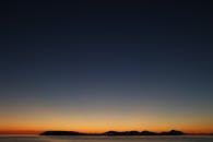 岛屿轮廓上，美丽的日落映衬着五彩缤纷的天空，非常适合自然和旅行主题