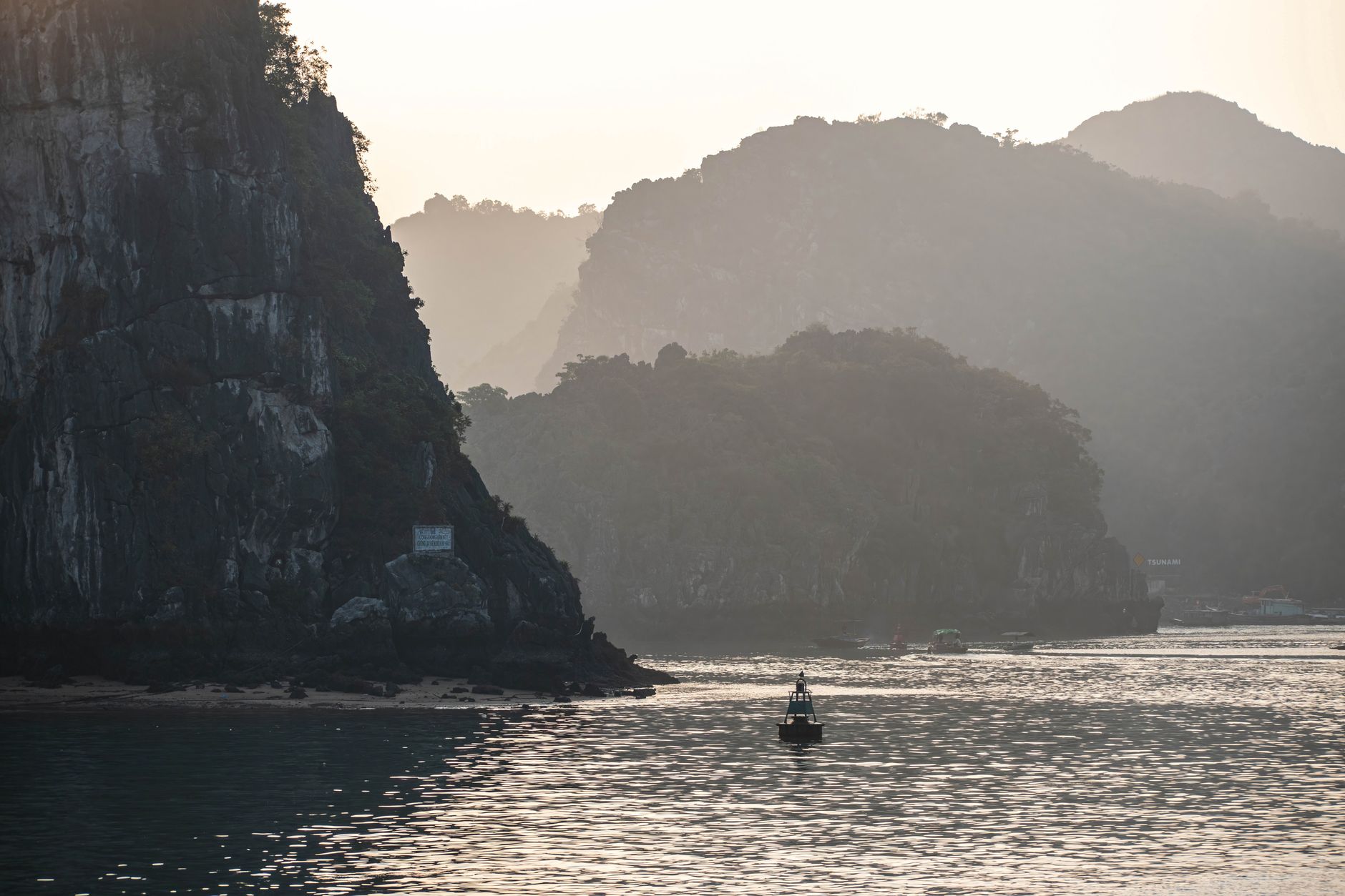 Peaceful view of Ha Long Bay with limestone cliffs in the evening light.