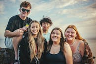 在阳光明媚的日子里，快乐的年轻朋友们在加利福尼亚州阿维拉海滩一起微笑摆姿势