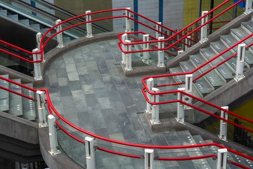 Free Contemporary staircase with vibrant red railings in a Rotterdam station, showcasing urban architecture. Stock Photo