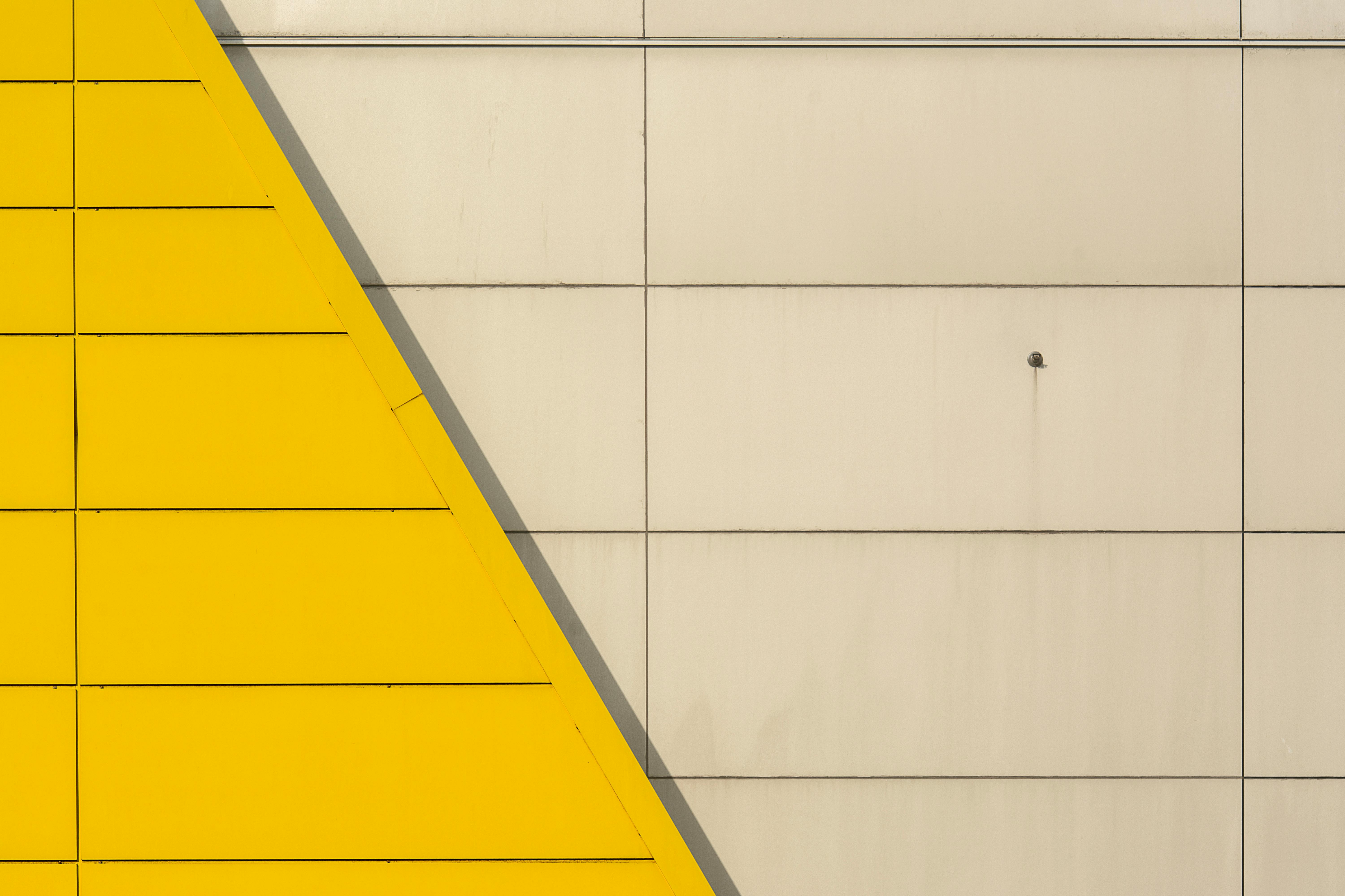 grátis Fachada arquitetônica abstrata com formas geométricas em tons de amarelo e cinza. Foto profissional