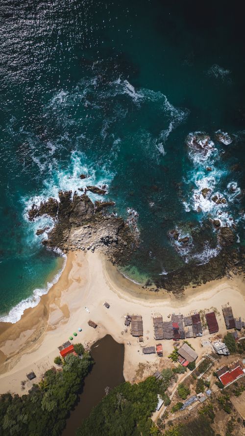 Free Stunning aerial shot of Oaxaca's coastline, featuring turquoise waters and rocky cliffs. Stock Photo