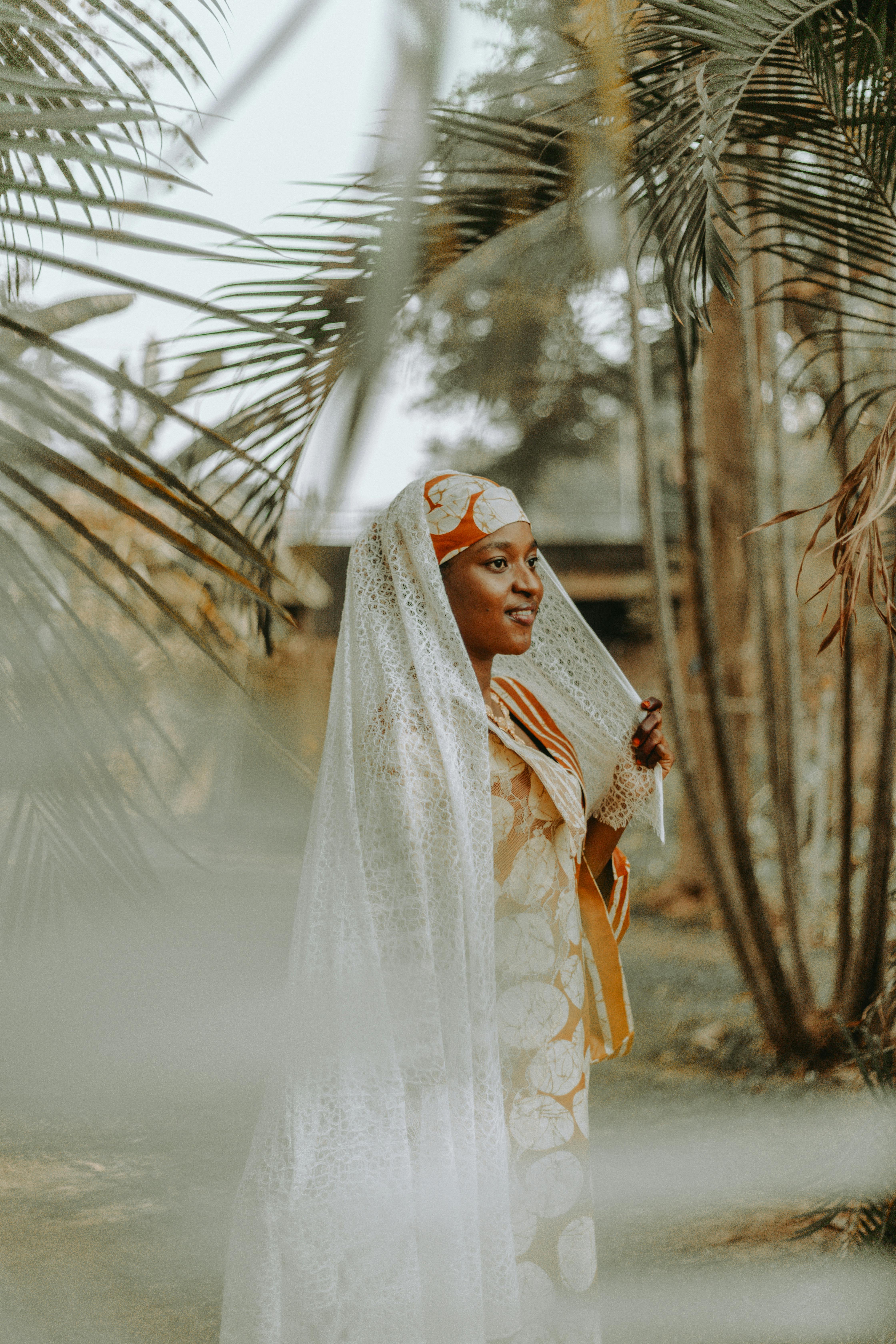 African woman in traditional clothing outdoors, exuding elegance and cultural heritage.
