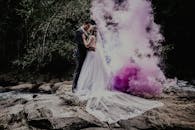 紫色烟雾中，新娘和新郎在自然环境中亲密相拥
