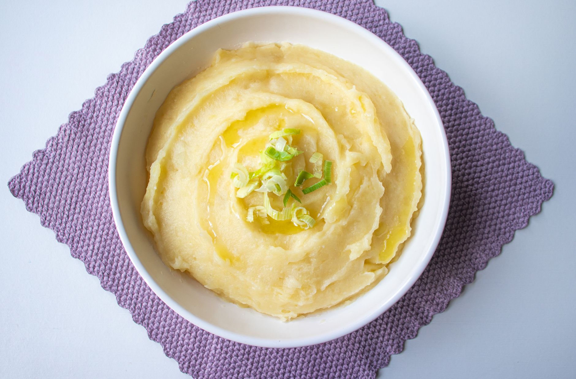 A bowl of creamy mashed potatoes with a pat of butter melting on top