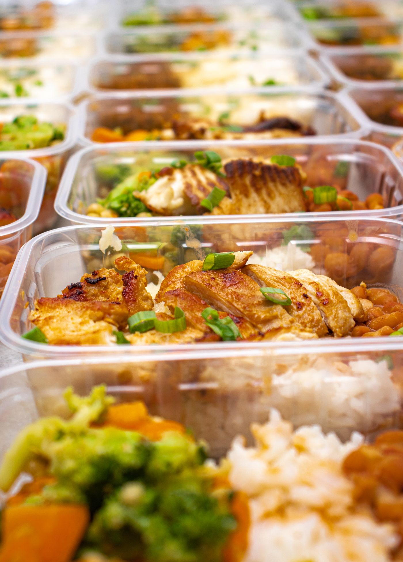 Colourful meal prep containers with grilled chicken, rice and vegetables