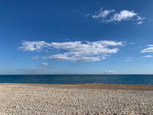 Free Tranquil pebble beach scene in Altea, Spain, under a clear blue sky. Stock Photo