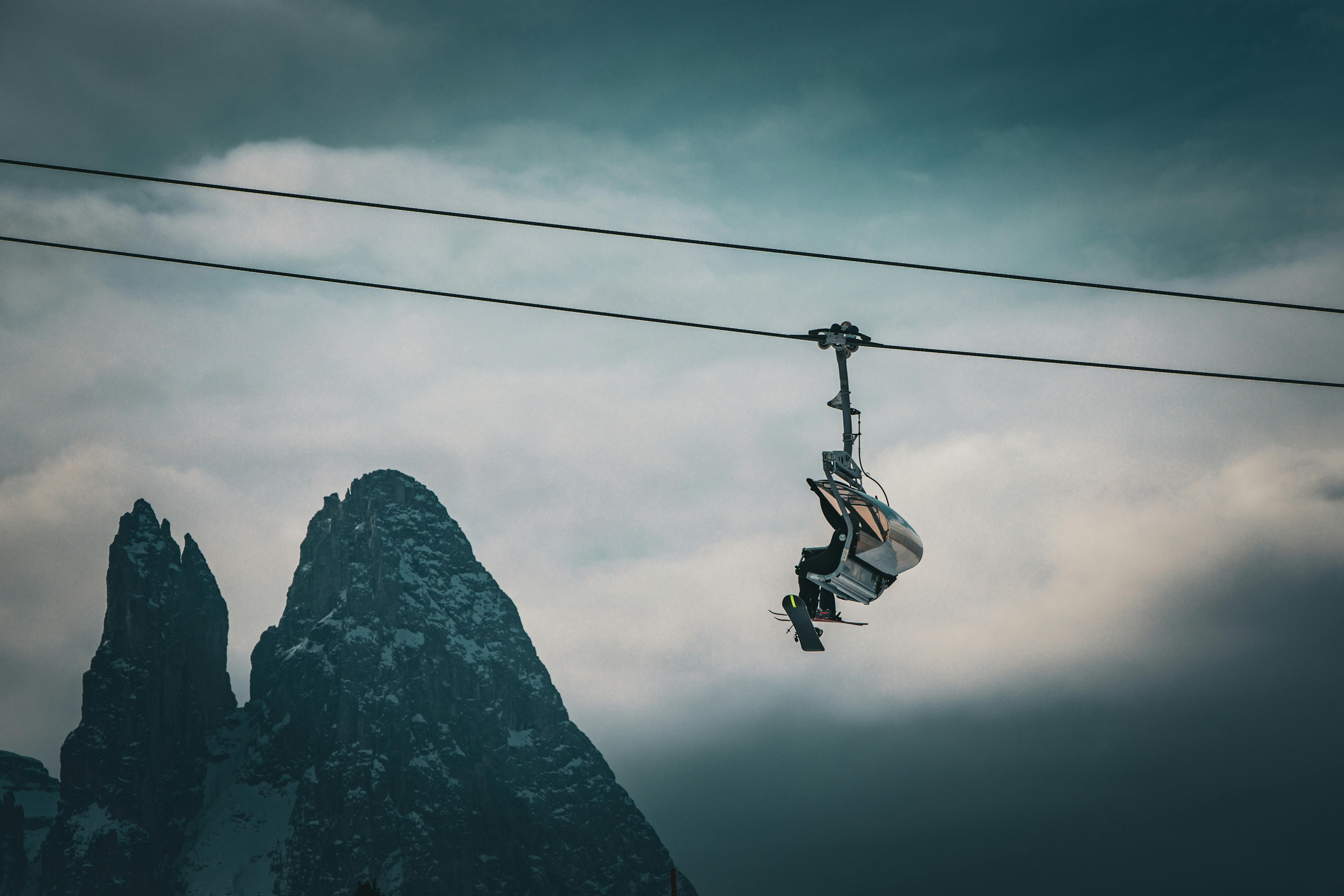 A ski lift against the scenic backdrop of the Dolomites in Trentino-Alto Adige, Italy, during winter.