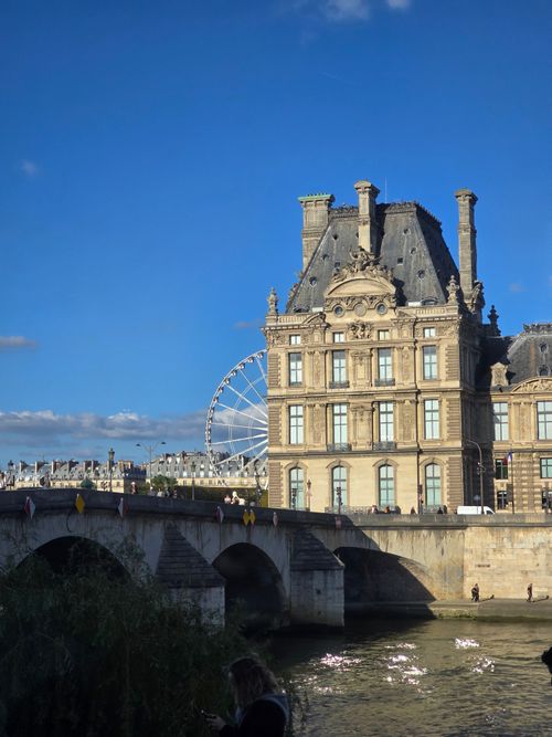 Free View of the Louvre Palace and Ferris Wheel against a clear blue sky in Paris, France. Stock Photo