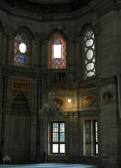 Free Detailed view of a mosque's interior showcasing stained glass and intricate architecture with Arabic calligraphy. Stock Photo