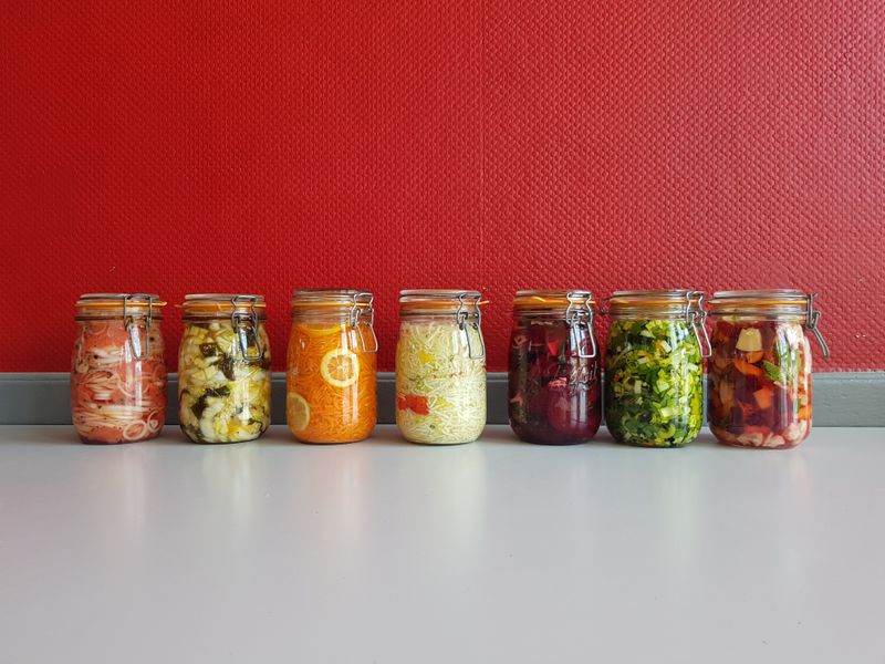 several empty and full mason jars lined up on a counter