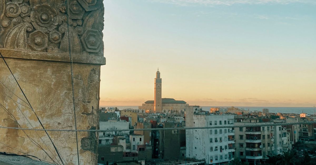 Captivating rooftop view of Casablanca featuring Hassan II Mosque at sunset.