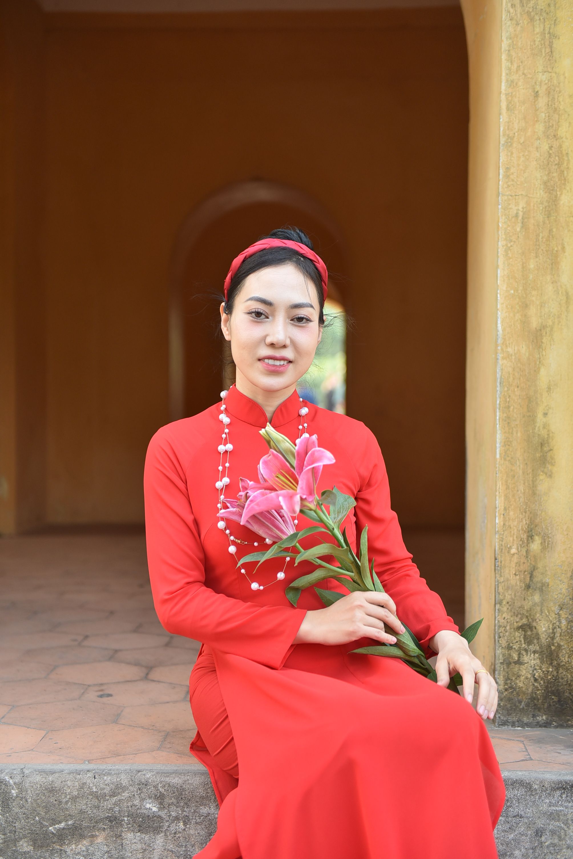 Woman in Traditional Red Dress Holding Lilies · Free Stock Photo