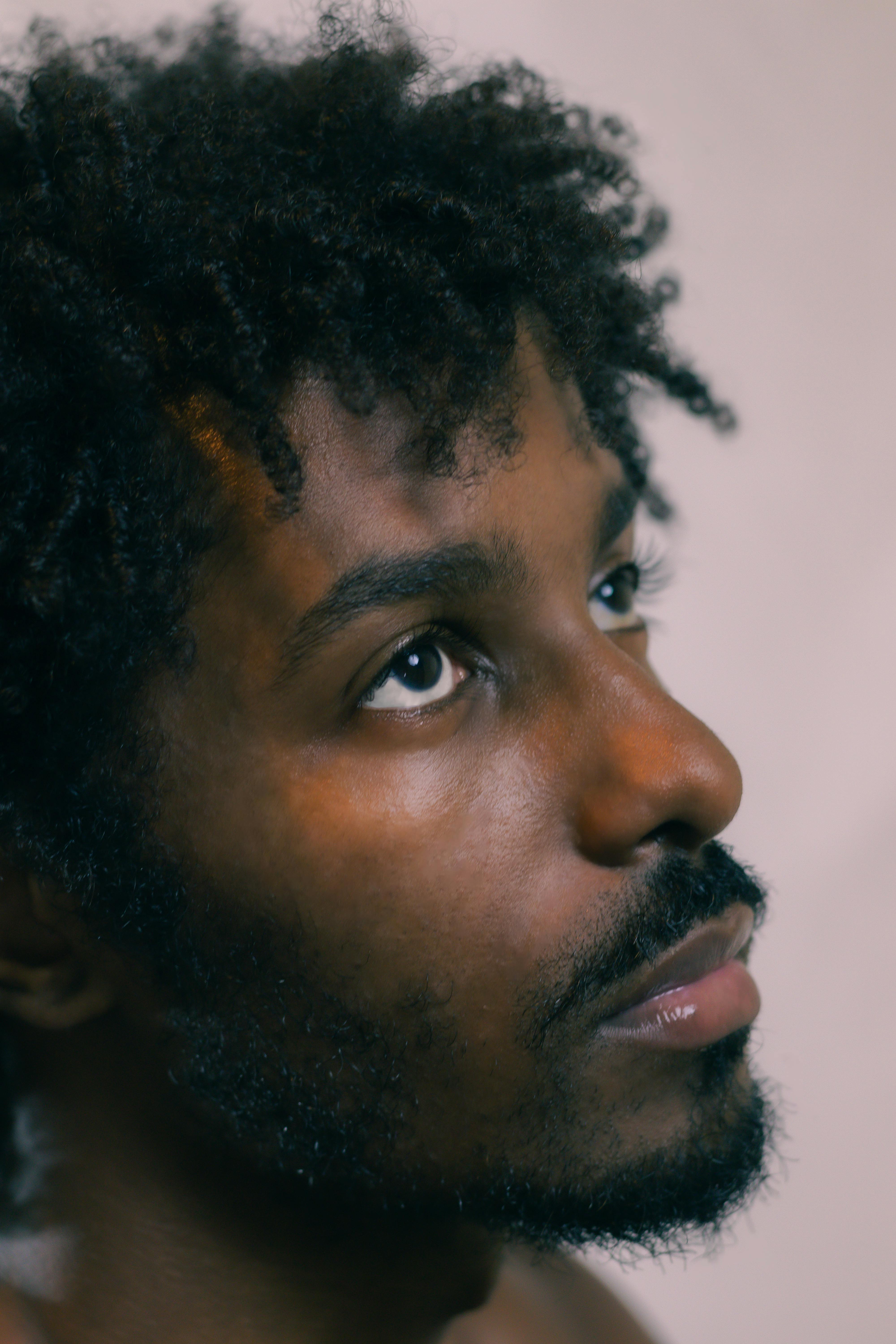 Close-up portrait of a man looking upward, thoughtful expression.