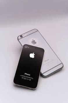 Two smartphones lying on a white surface, showcasing sleek design and advanced technology.