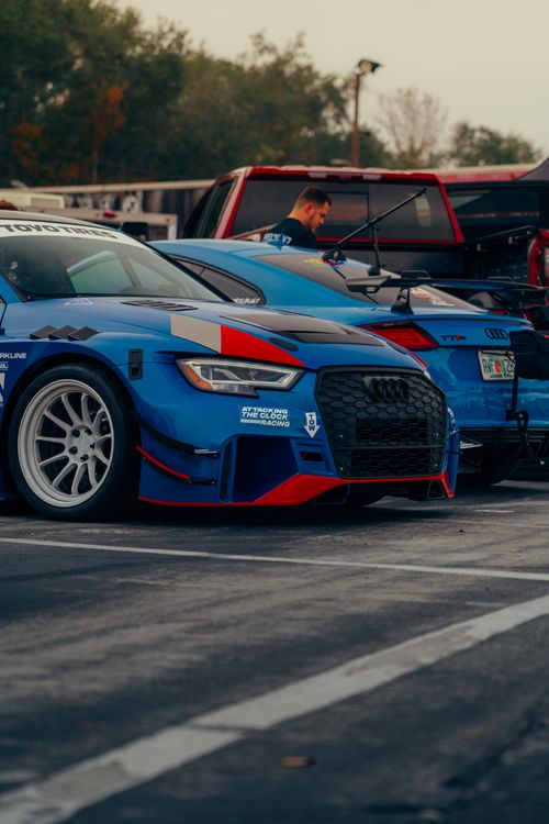 Free Close-up of blue racing cars parked outdoors in a racing event setting. Stock Photo