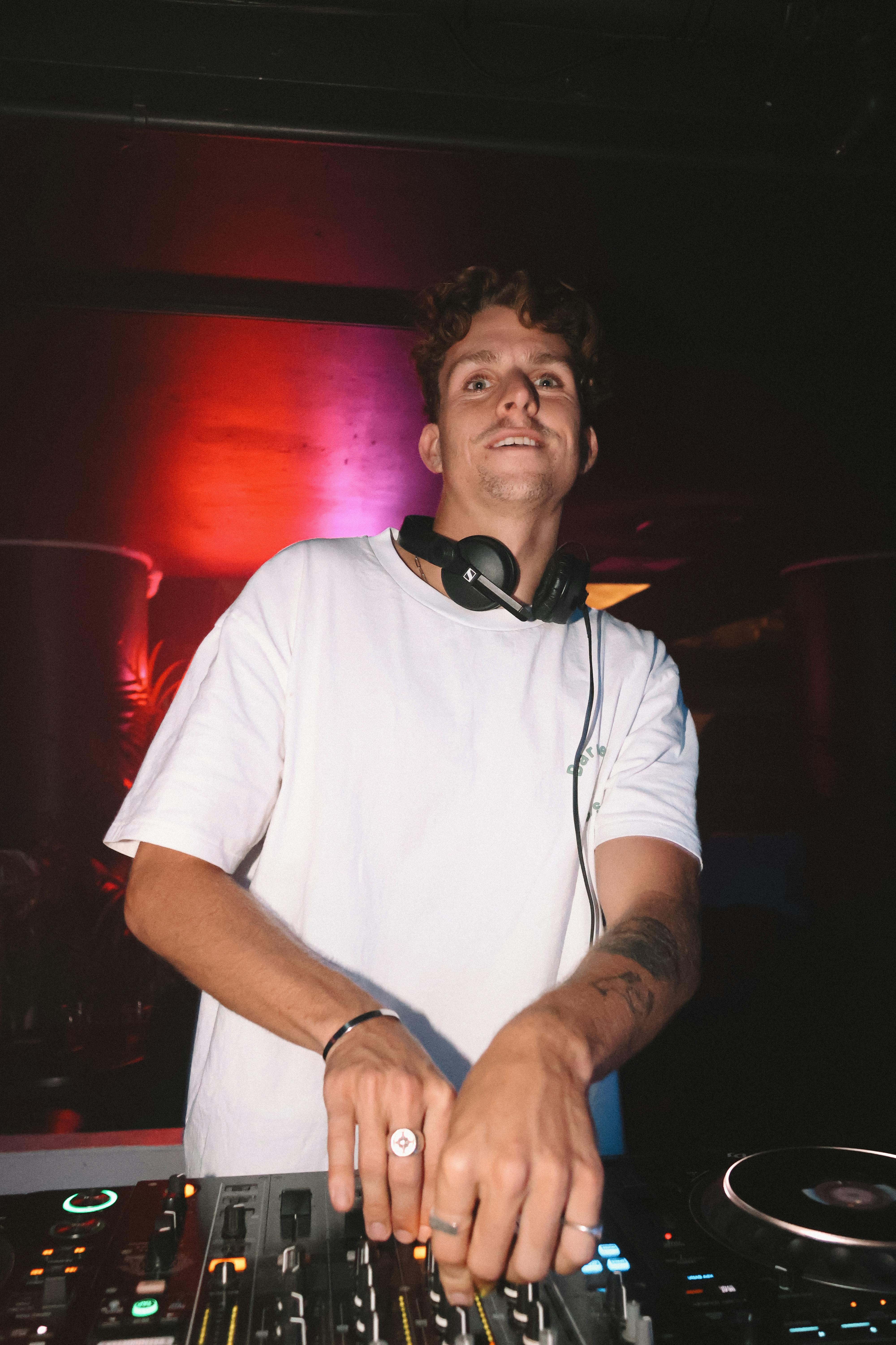 DJ mixing tracks in a vibrant nightclub setting under dynamic lighting.