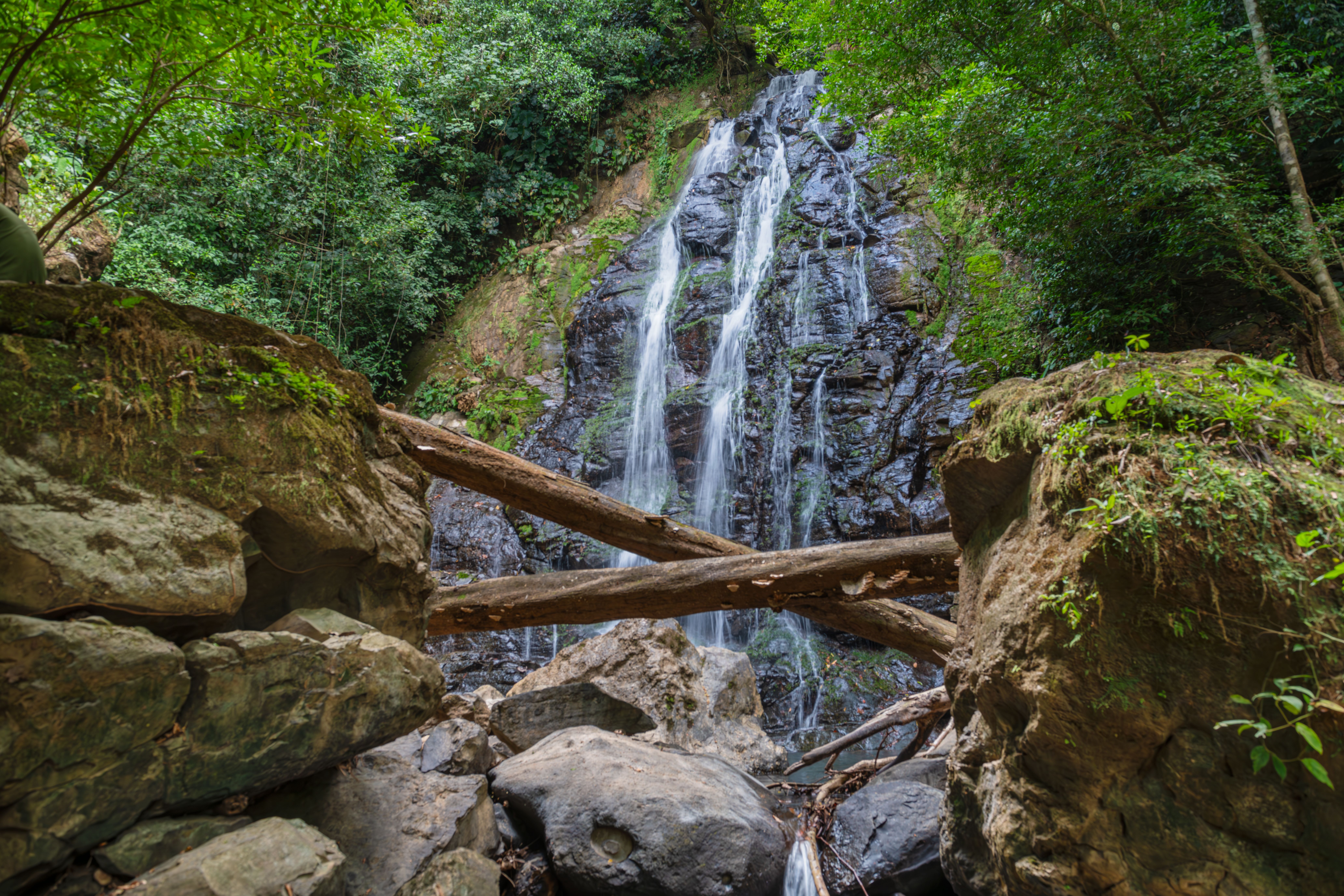 A beautiful waterfall cascading through rocks amidst dense forest in Costa Rica.