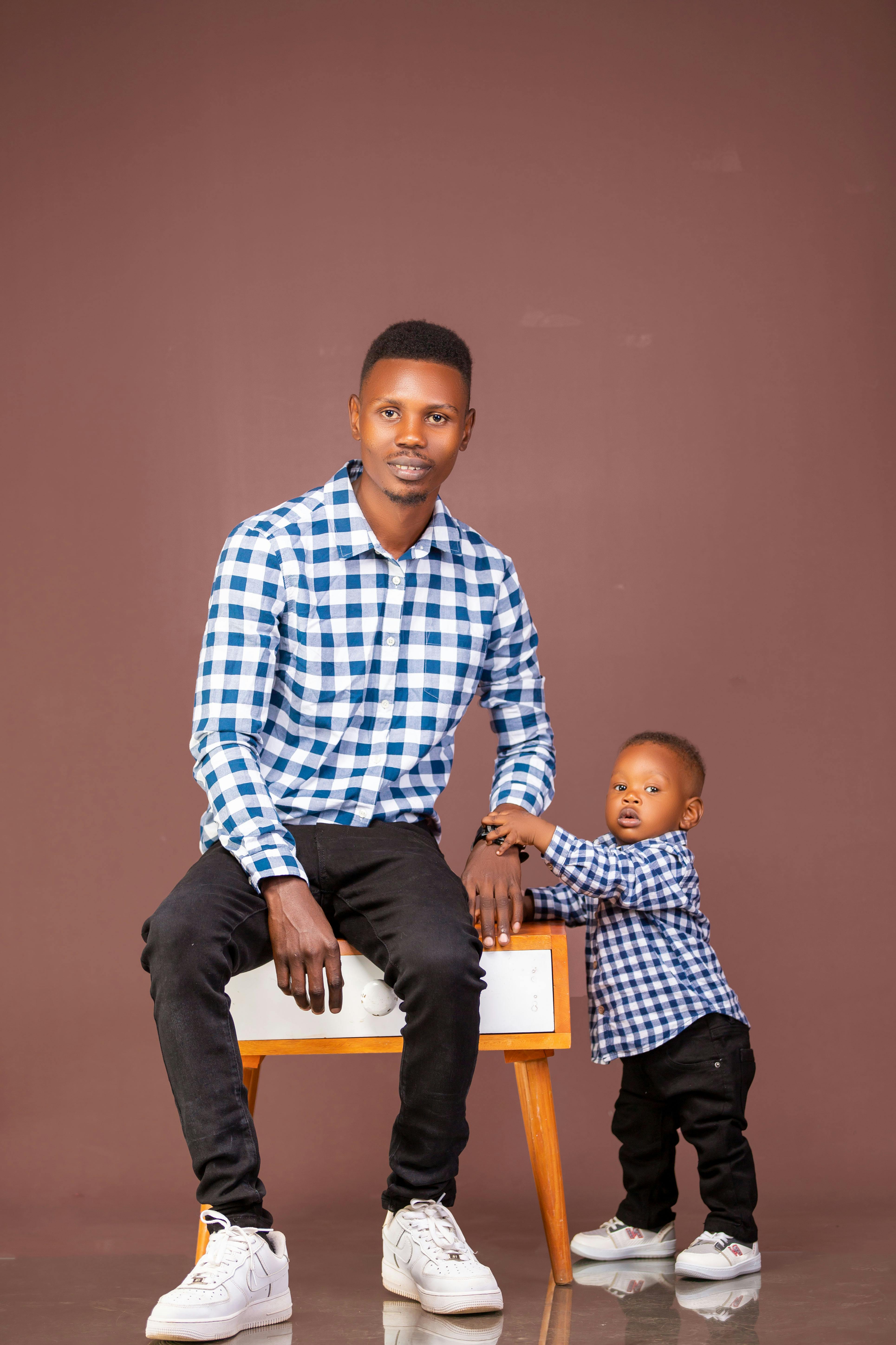 Gratuit Portrait de père et fils en chemises à carreaux bleus à l'intérieur. Photos