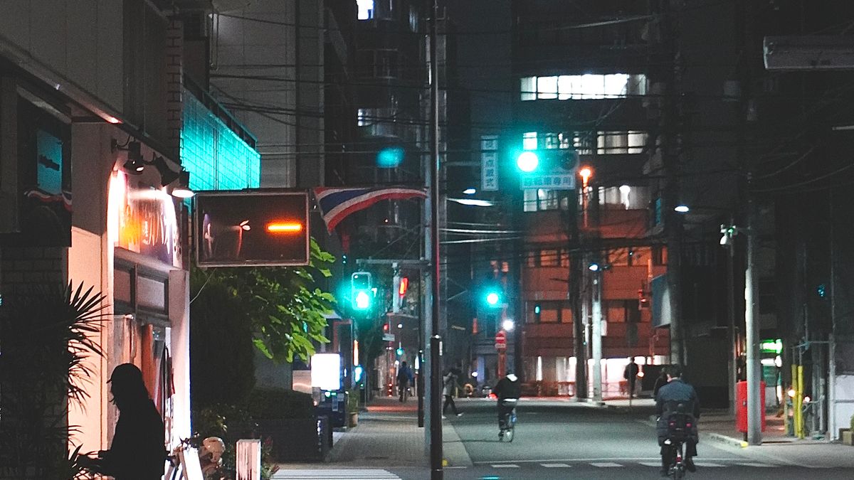 Busy Tokyo street at night with bright signs and pedestrians