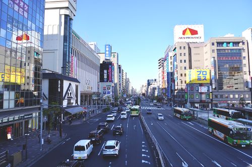 Free Bustling Tokyo street scene with skyscrapers and busy traffic on a clear day. Stock Photo