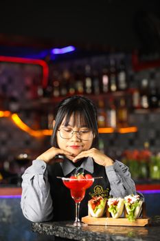 Bartender enjoying cocktails and tacos at modern bar.