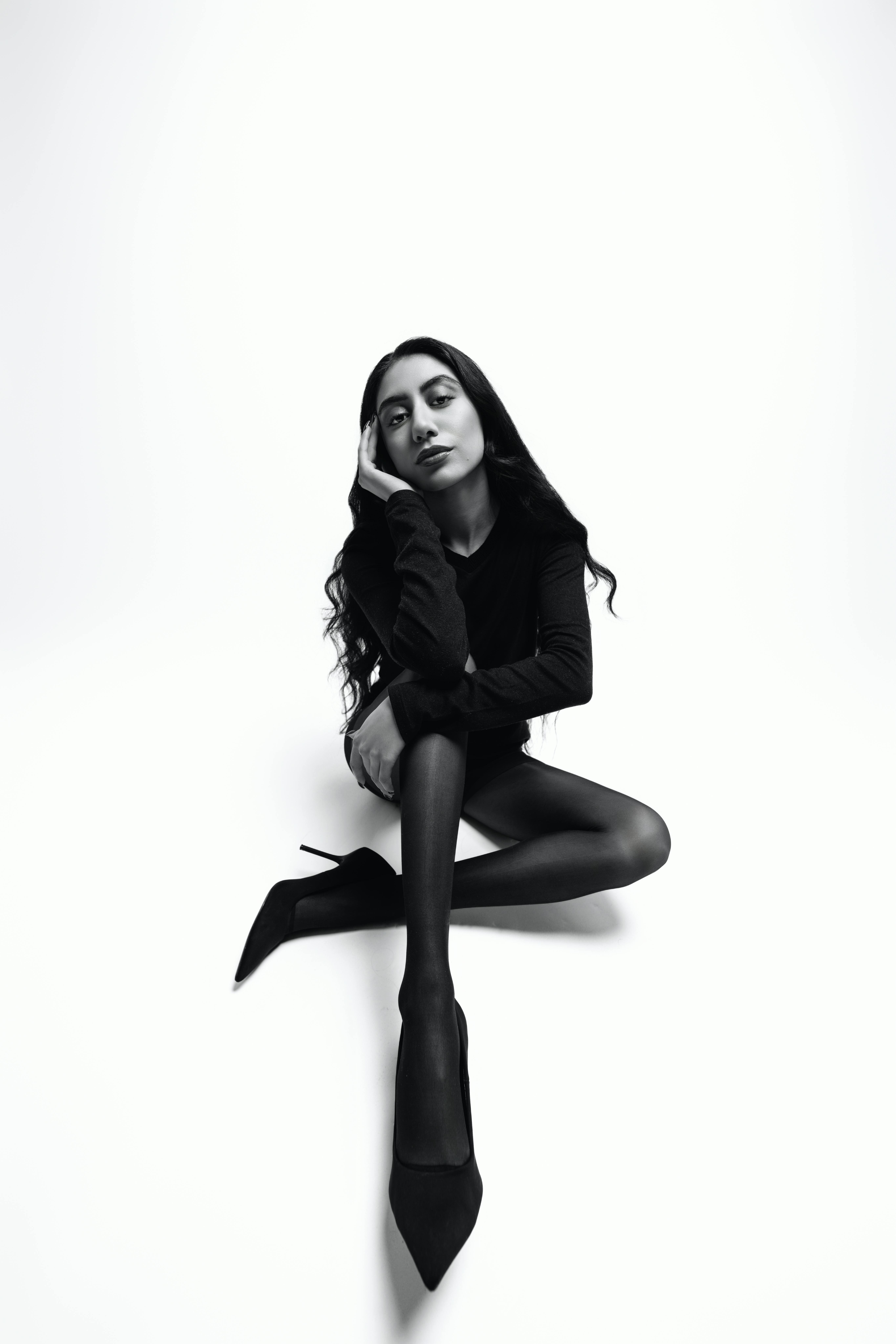 Striking monochrome portrait of a model in a sophisticated black outfit exuding elegance and confidence.